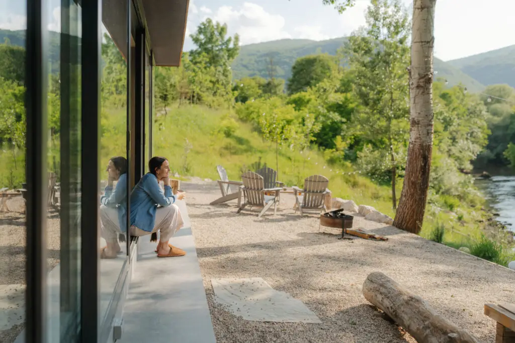 A woman enjoying a peaceful moment outdoors beside a river valley